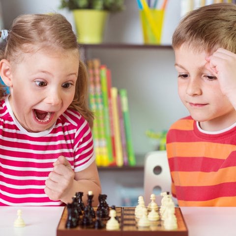 Niños jugando al ajedrez.