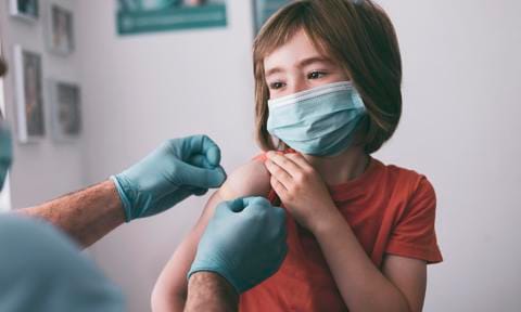 Calendario vacunacional 2023. Niño vacunándose en consulta con un enfermero.