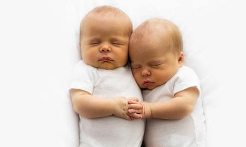 Gemelos abrazados recién nacidos