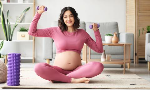 Embarazada con pesas mientras hace ejercicio