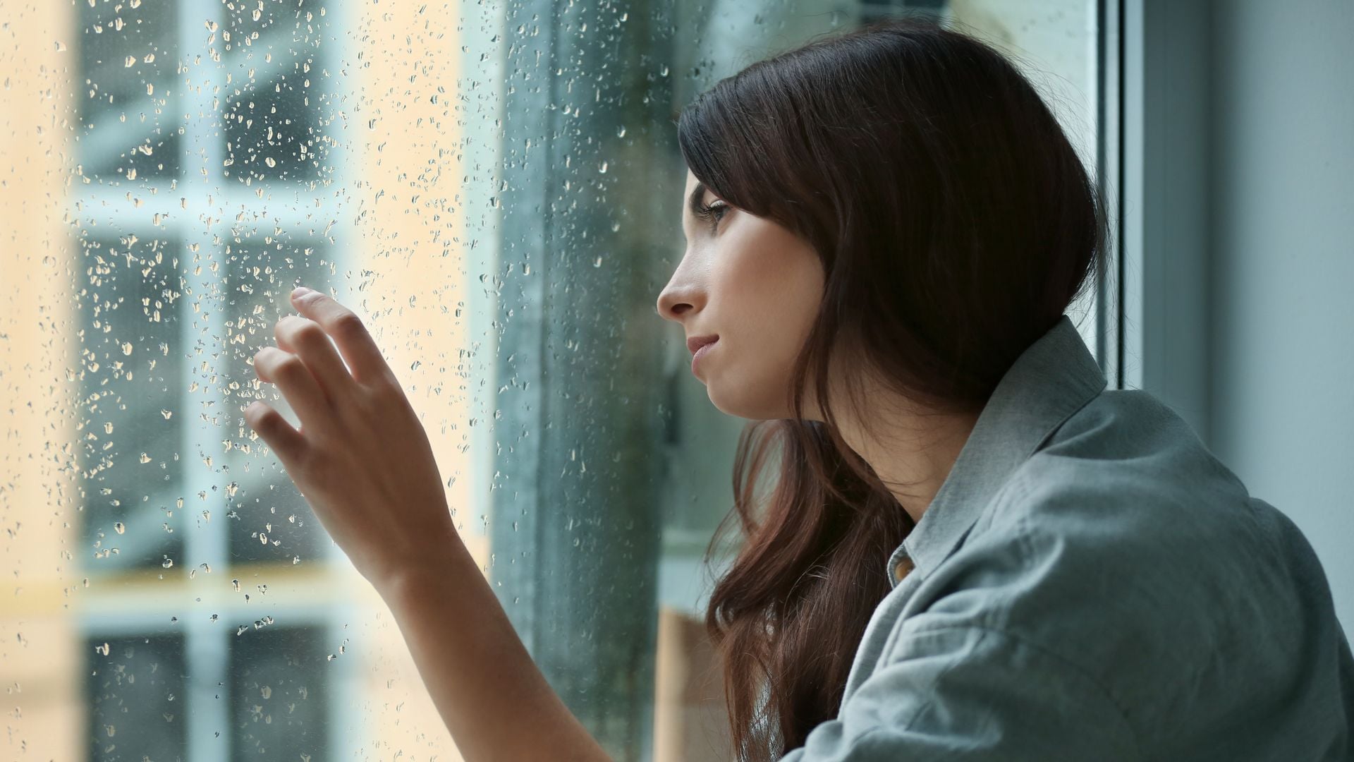 mujer deprimida mirando por la ventana