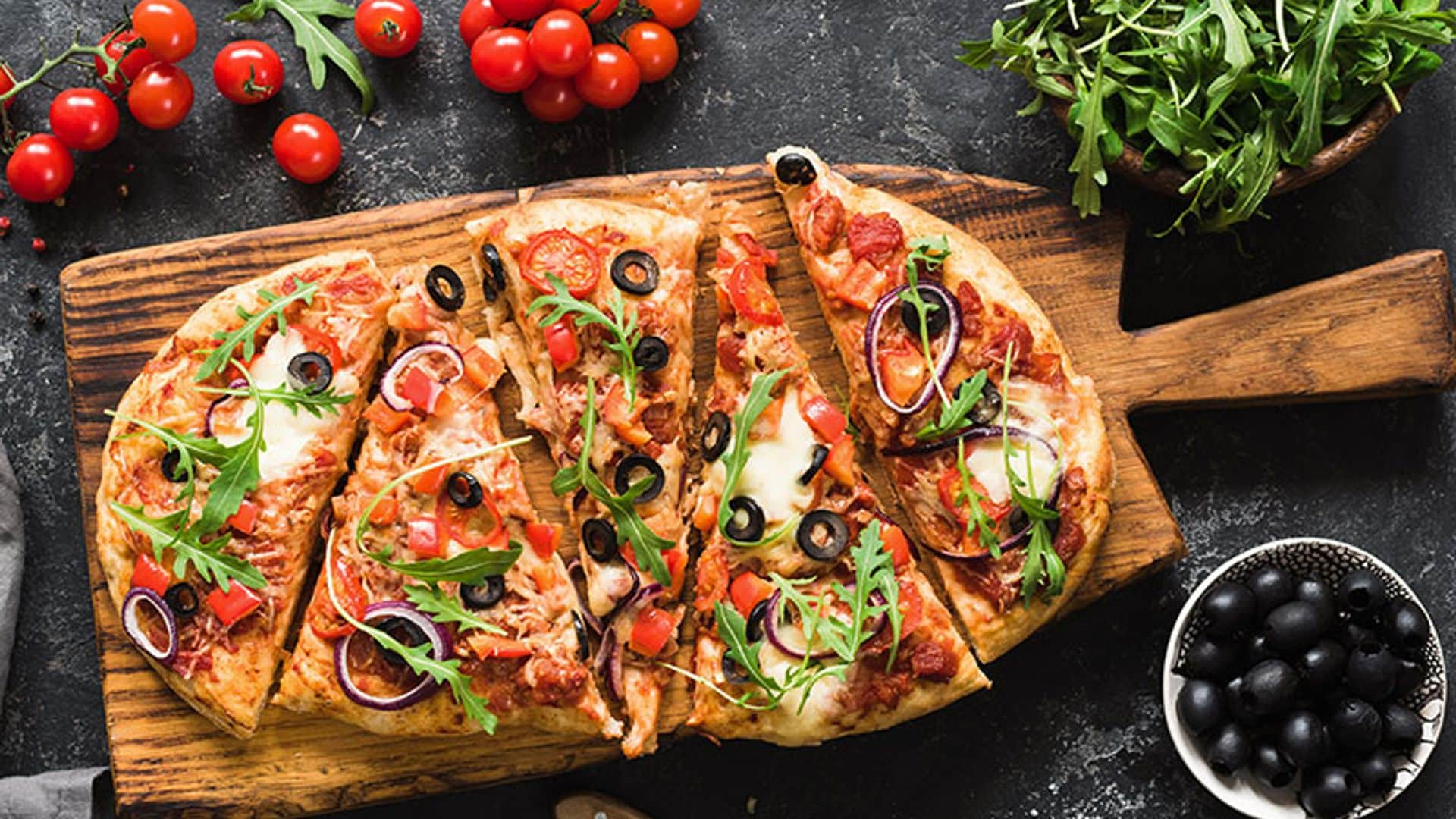 Pizza casera con tomate fresco, aceitunas y rúcula