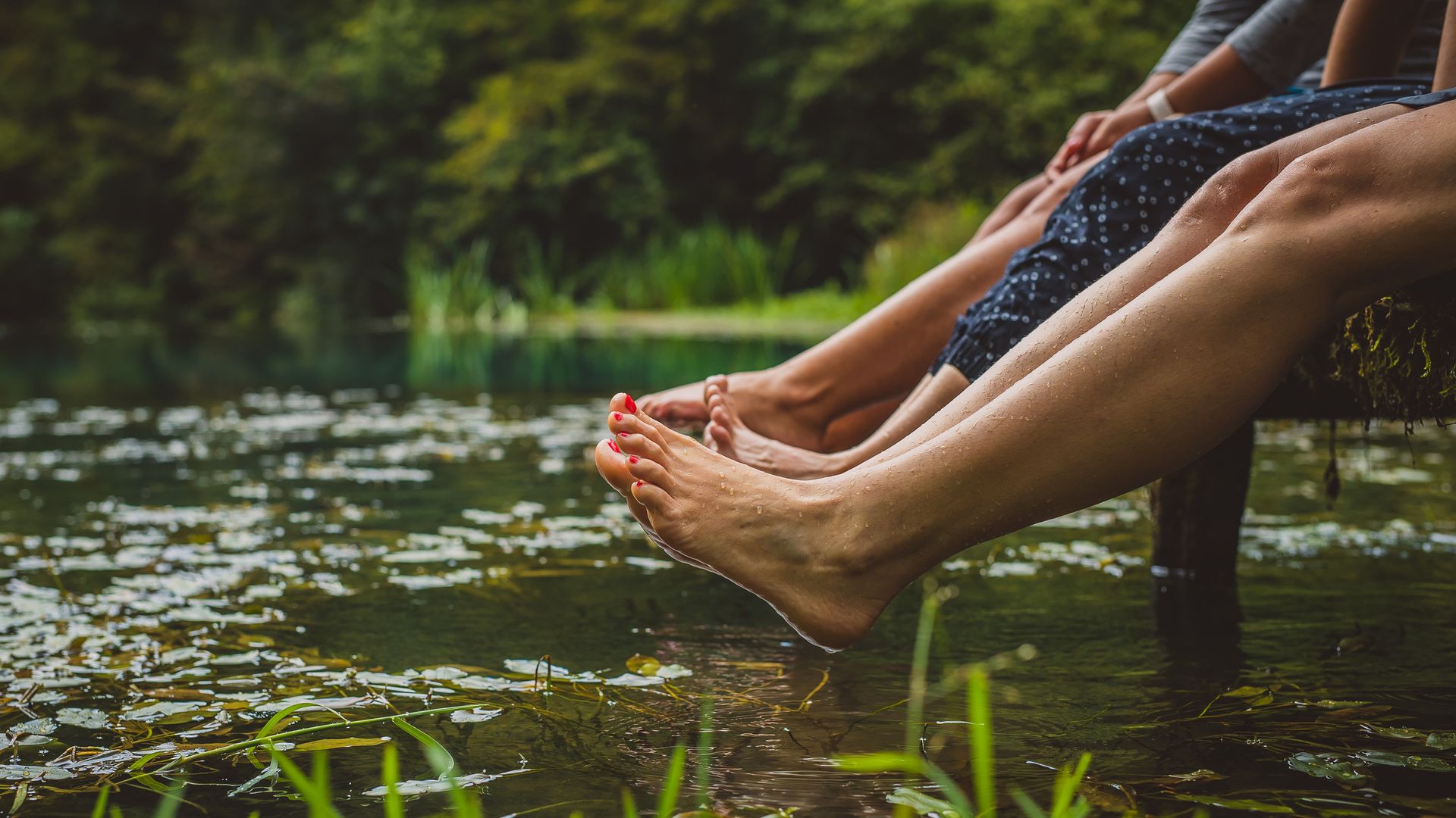 piernas de mujer en verano, en un muelle, junto al agua