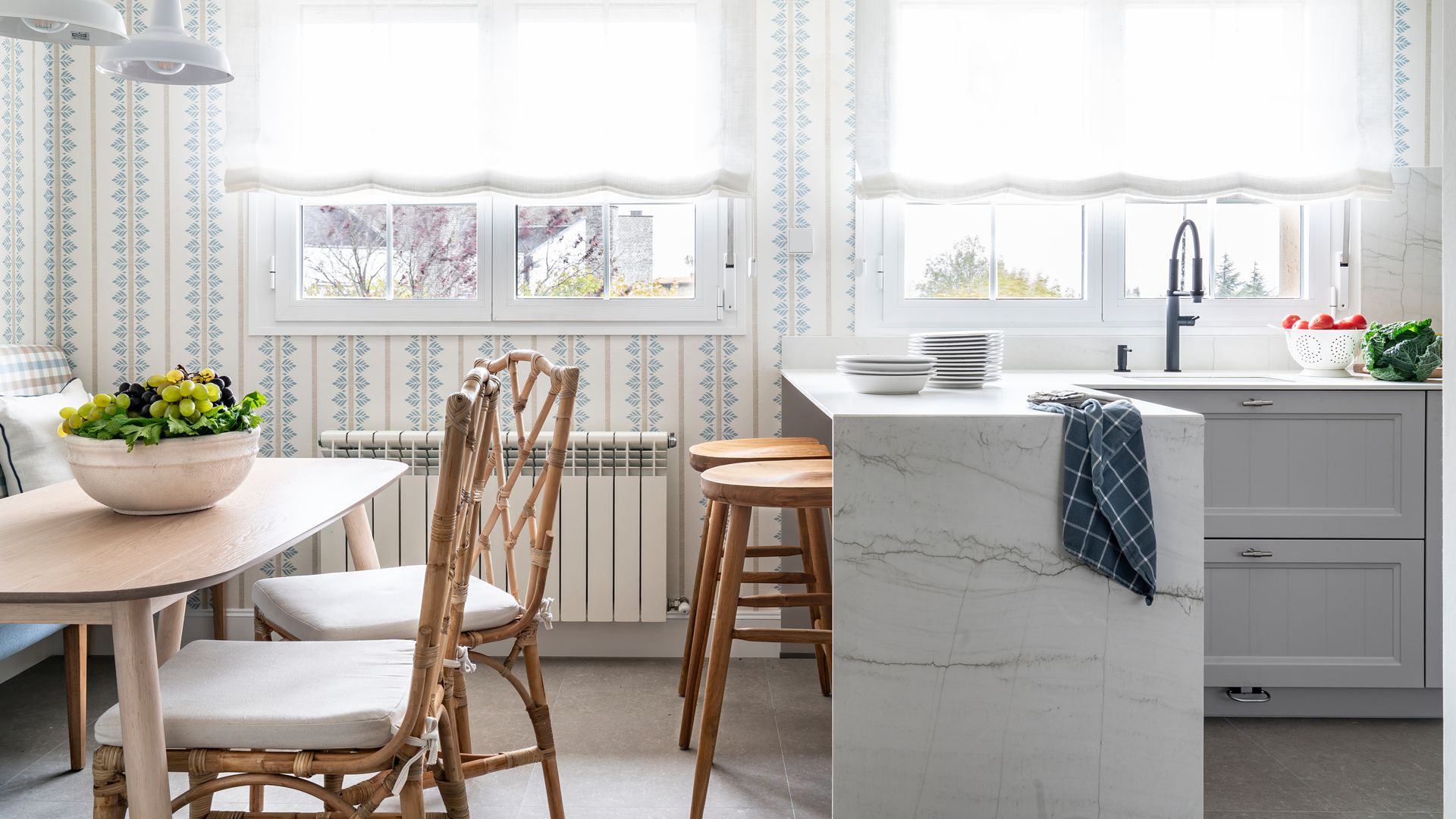 Cocina con papel pintado de hojas azul y blanco, office con banco y península