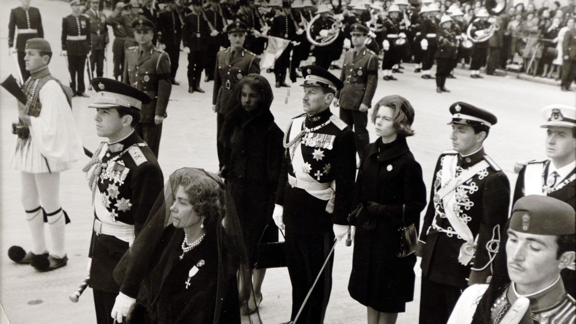 Funeral por el rey Pablo I de Grecia en marzo de 1964, en primera fila está el nuevo rey, Constantino II, junto a su madre, la reina viuda Federica. En segunda fila, cubierta de luto, la reina Sofía, la princesa Irene, el príncipe Miguel y el rey Juan Carlos