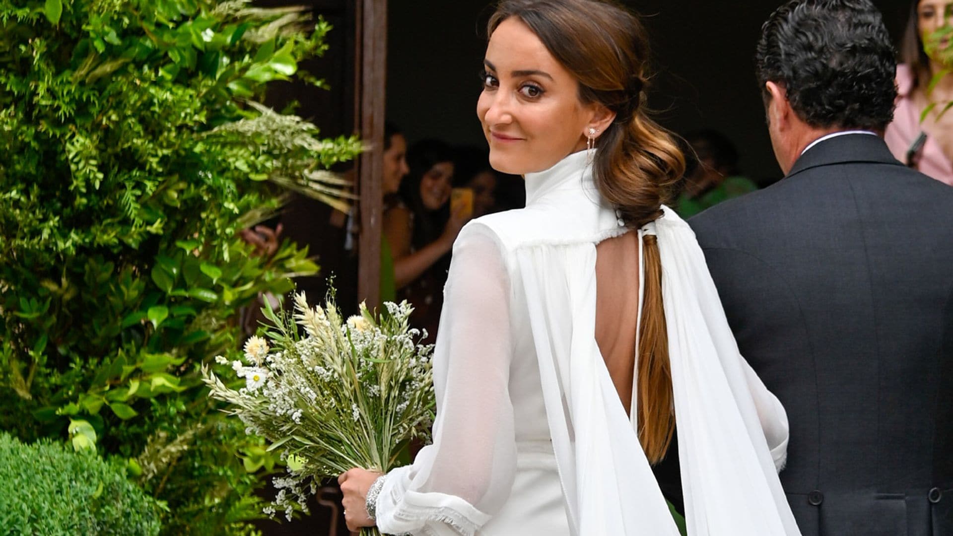 Lucía Pombo se casa con un vestido de cuello chimenea y capa vaporosa