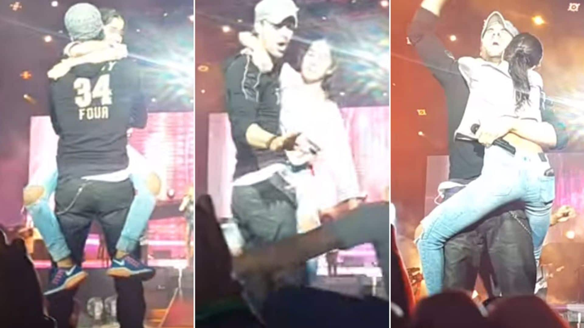 La reacción de Enrique Iglesias cuando una fan salta al escenario, le abraza... ¡y se niega a soltarle!