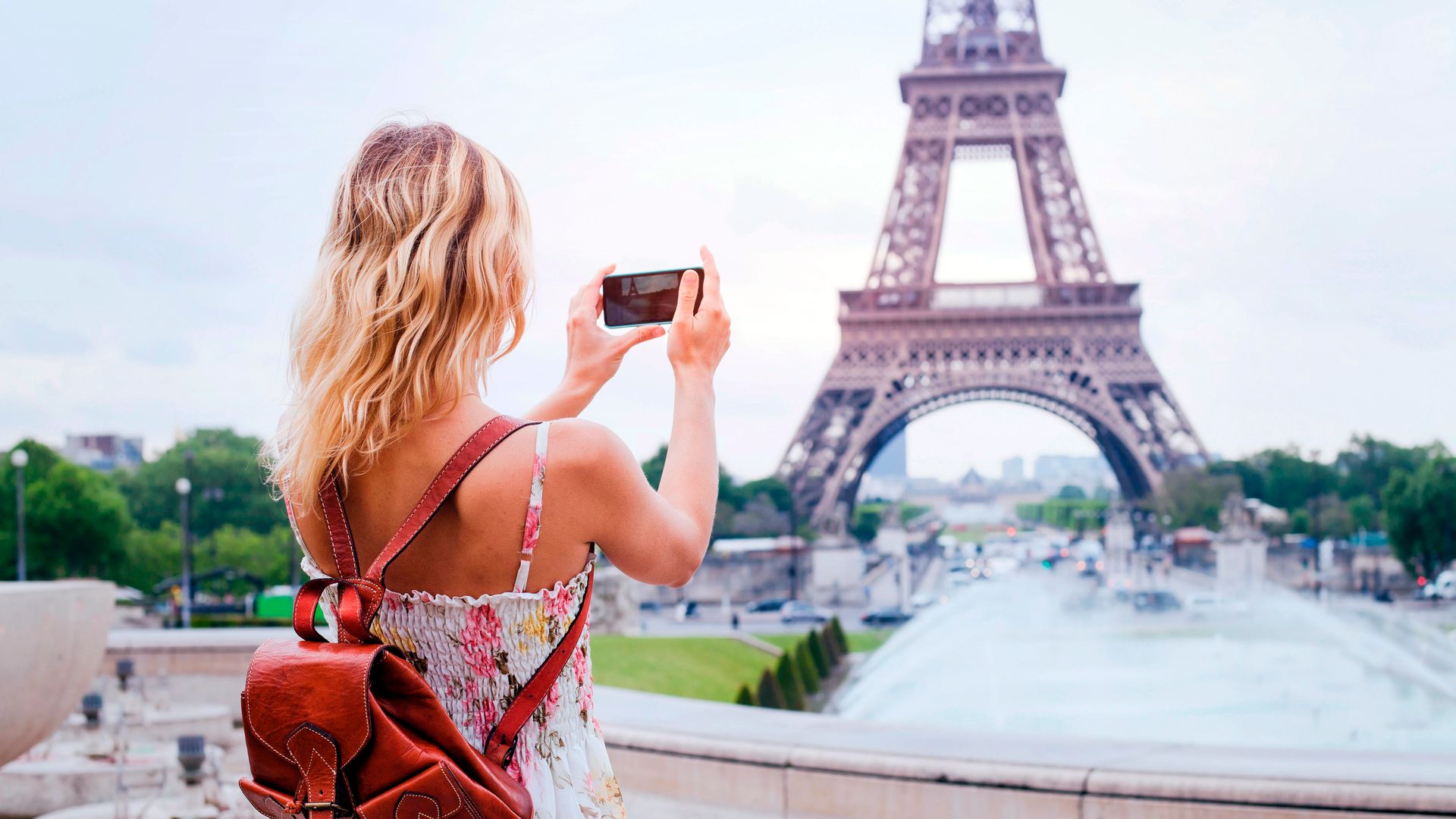 Turista tomando una foto de la torre Eiffel de París durante el verano