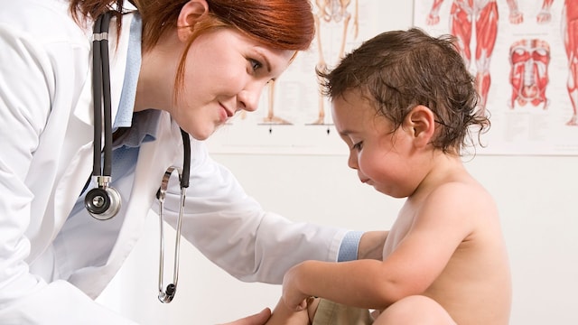 Pediatra en su consulta atendiendo a un bebé