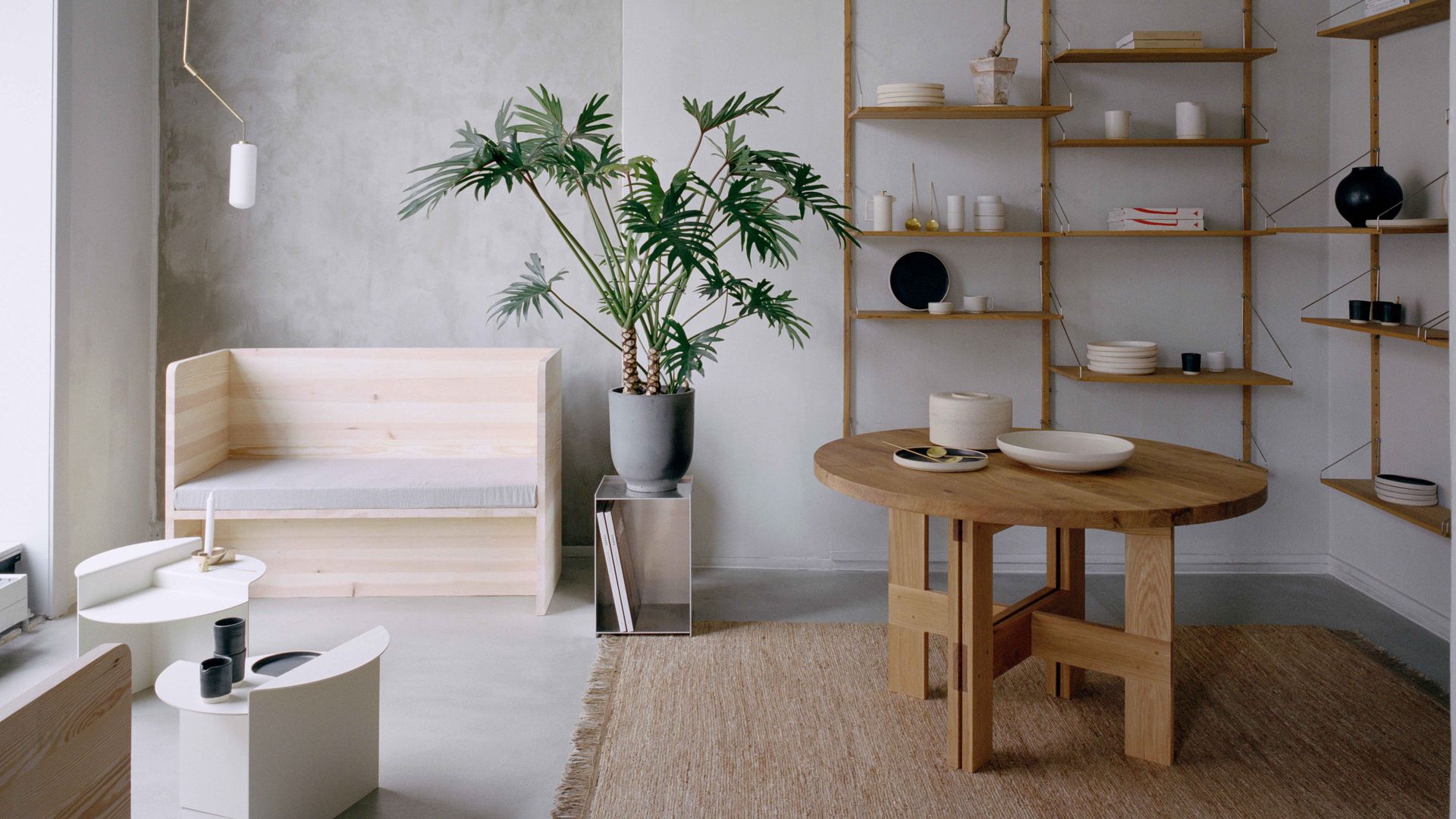 Salón minimalista con sofá y estanterías de madera y revistero metálico