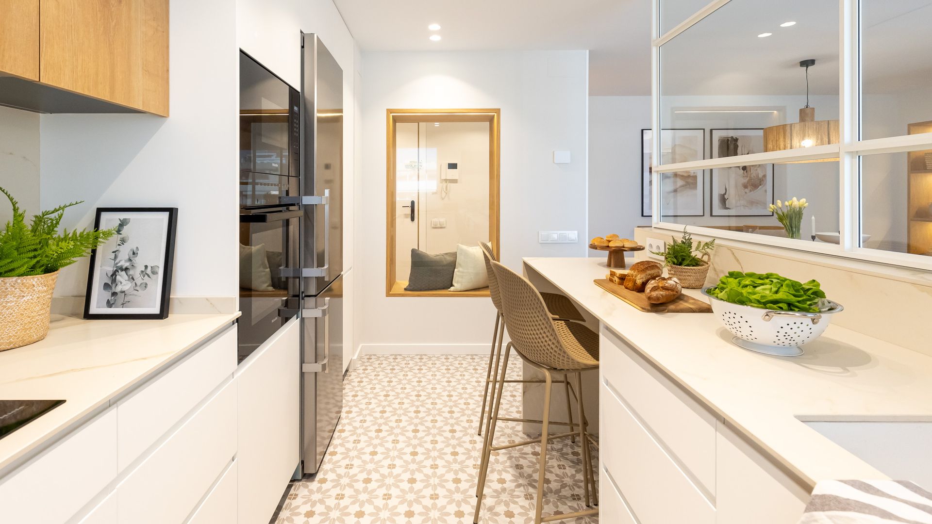 Cocina con muebles en color blanco y suelo hidráulico