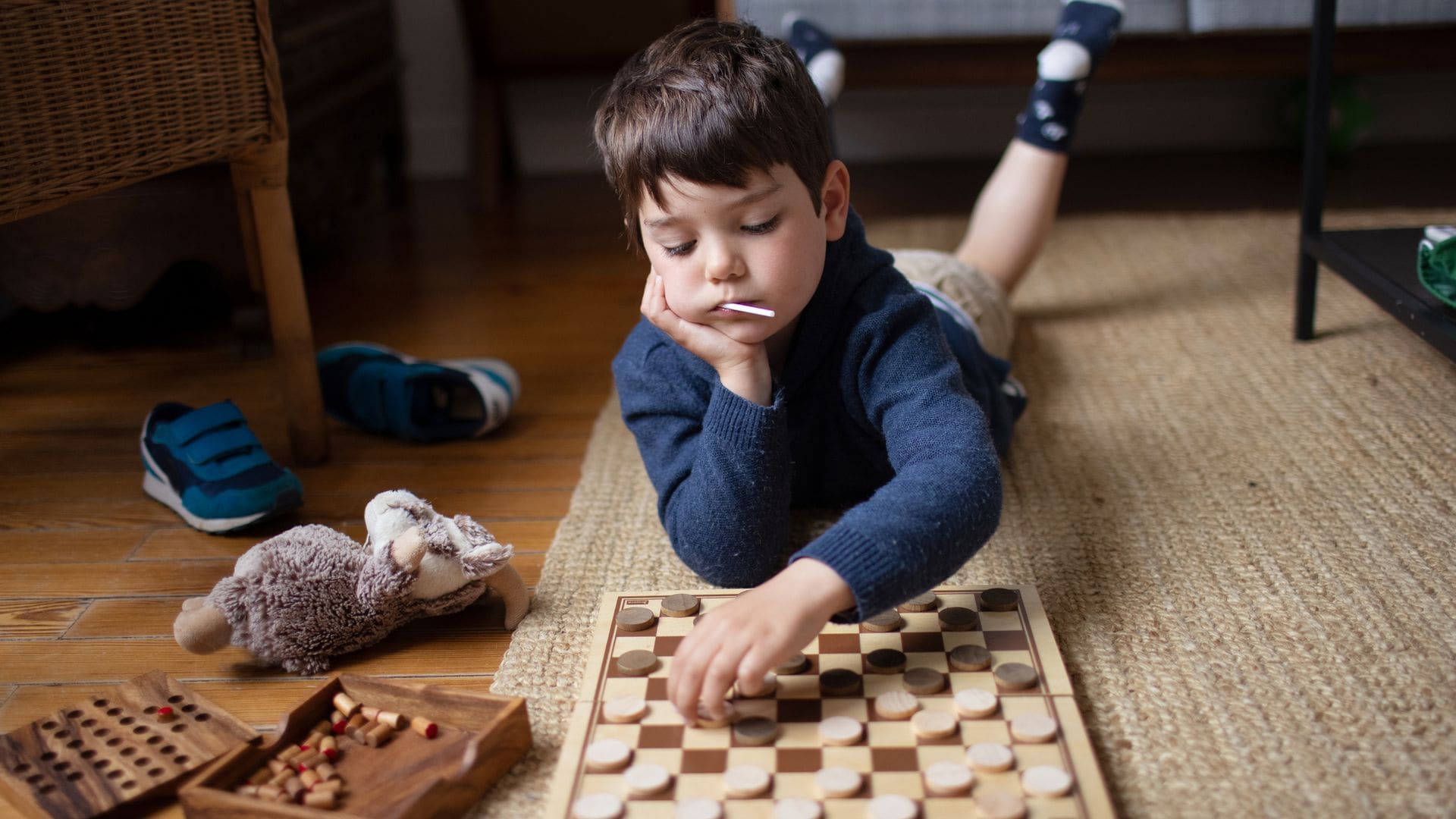 Niño juega al ajedrez solo en el suelo