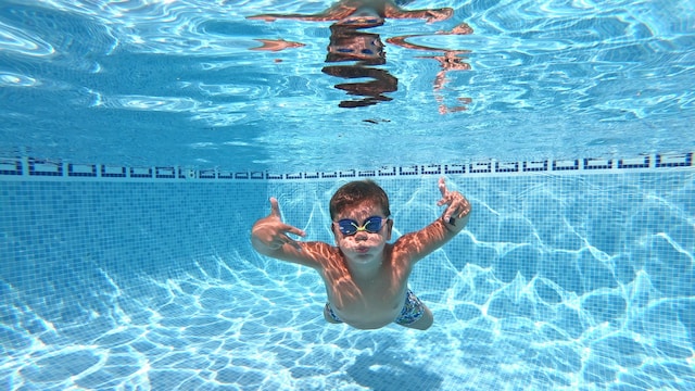 Niño pequeño nada bajo el agua