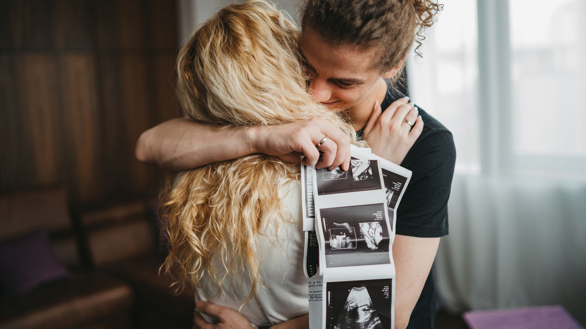 Pareja feliz tras ver primeras ecografías de su embarazo