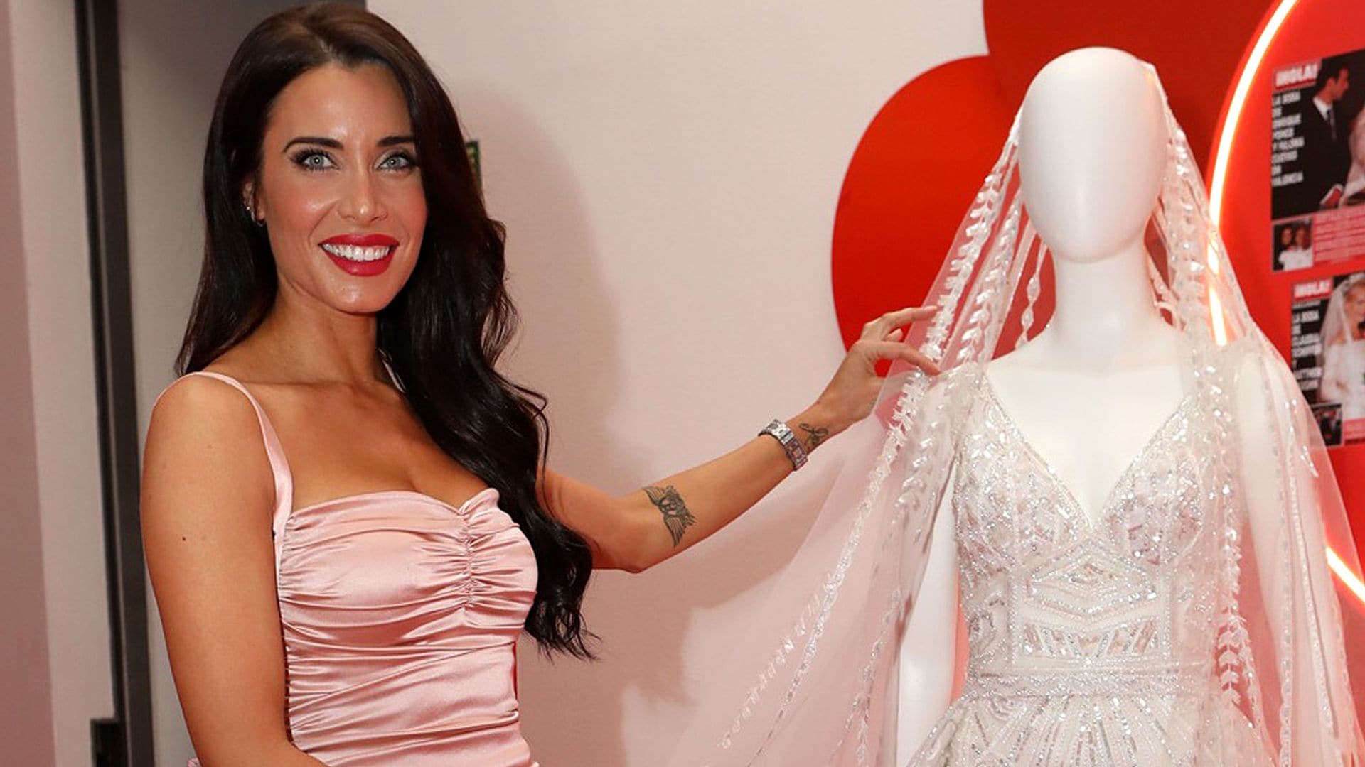 Pilar Rubio posa al lado de su vestido de novia expuesto en el Palacio de las Alhajas