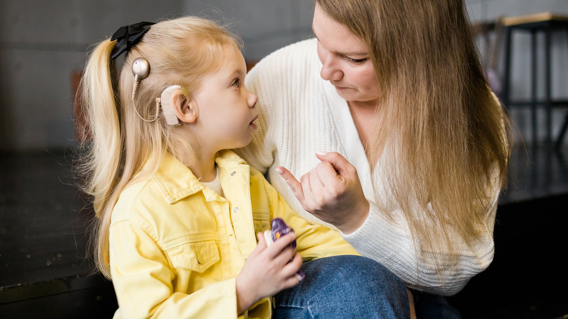 Madre habla con su hija, que lleva un implante coclear