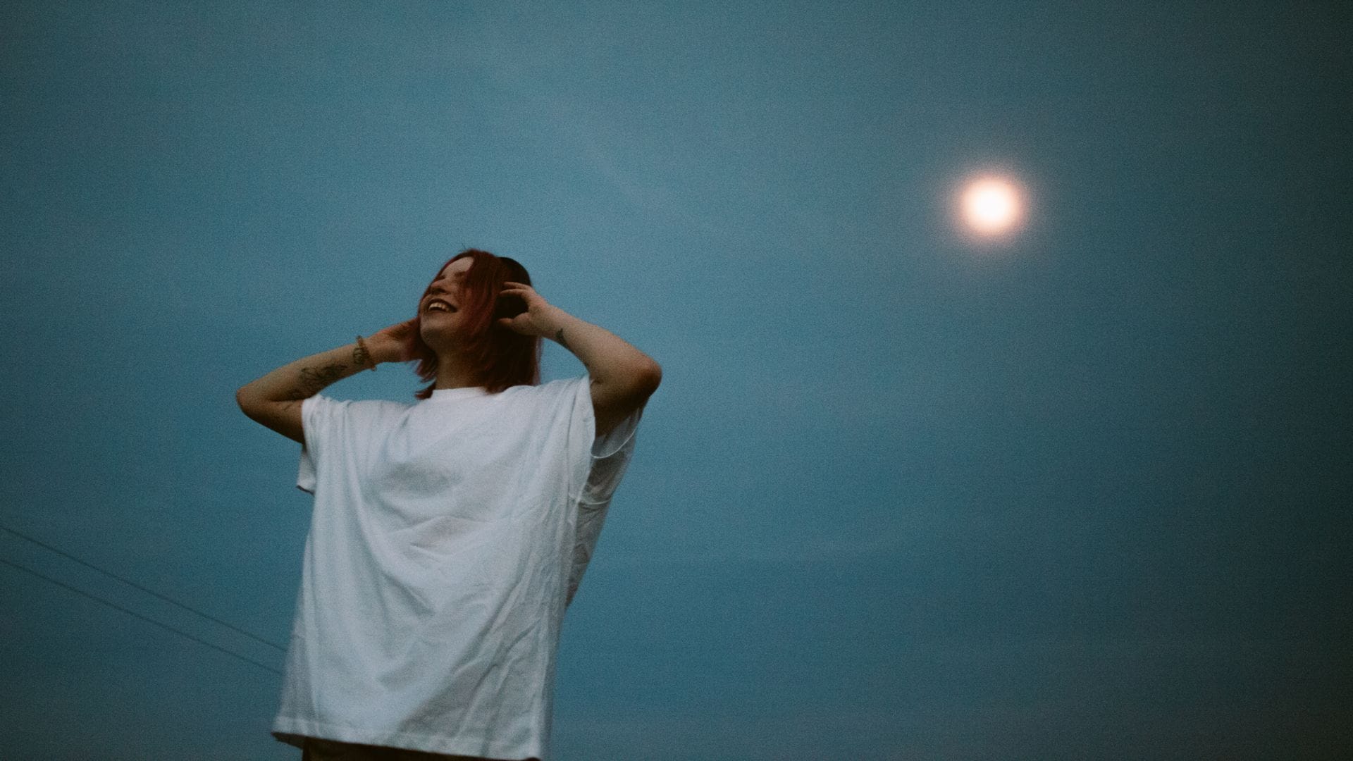 Mujer escuchando música con auriculares bajo la luz del amanecer. Mercurio retrógado.