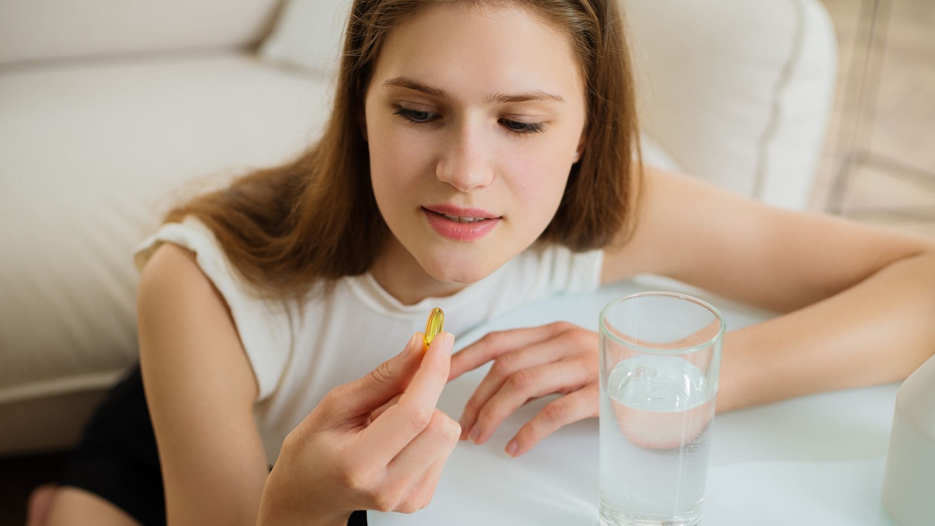 Mujer joven tomándose un suplemento de omega3