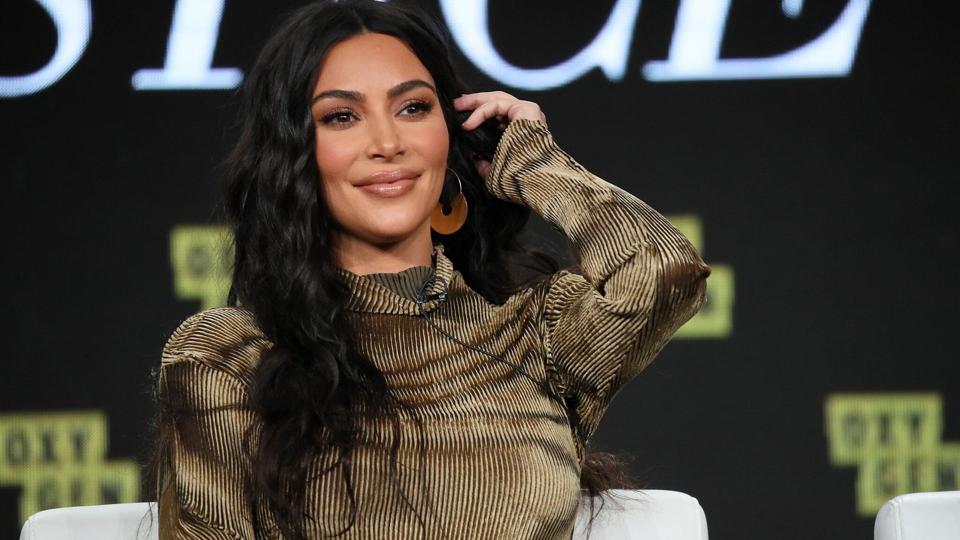 kim kardashian con cabello suelto ondas y raya en el medio