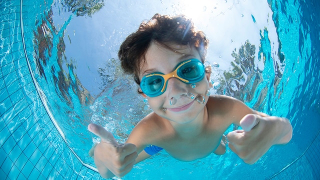 Niño buceando en la piscina feliz