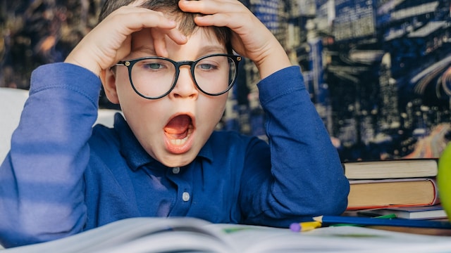 Niño cansado delante de un libro