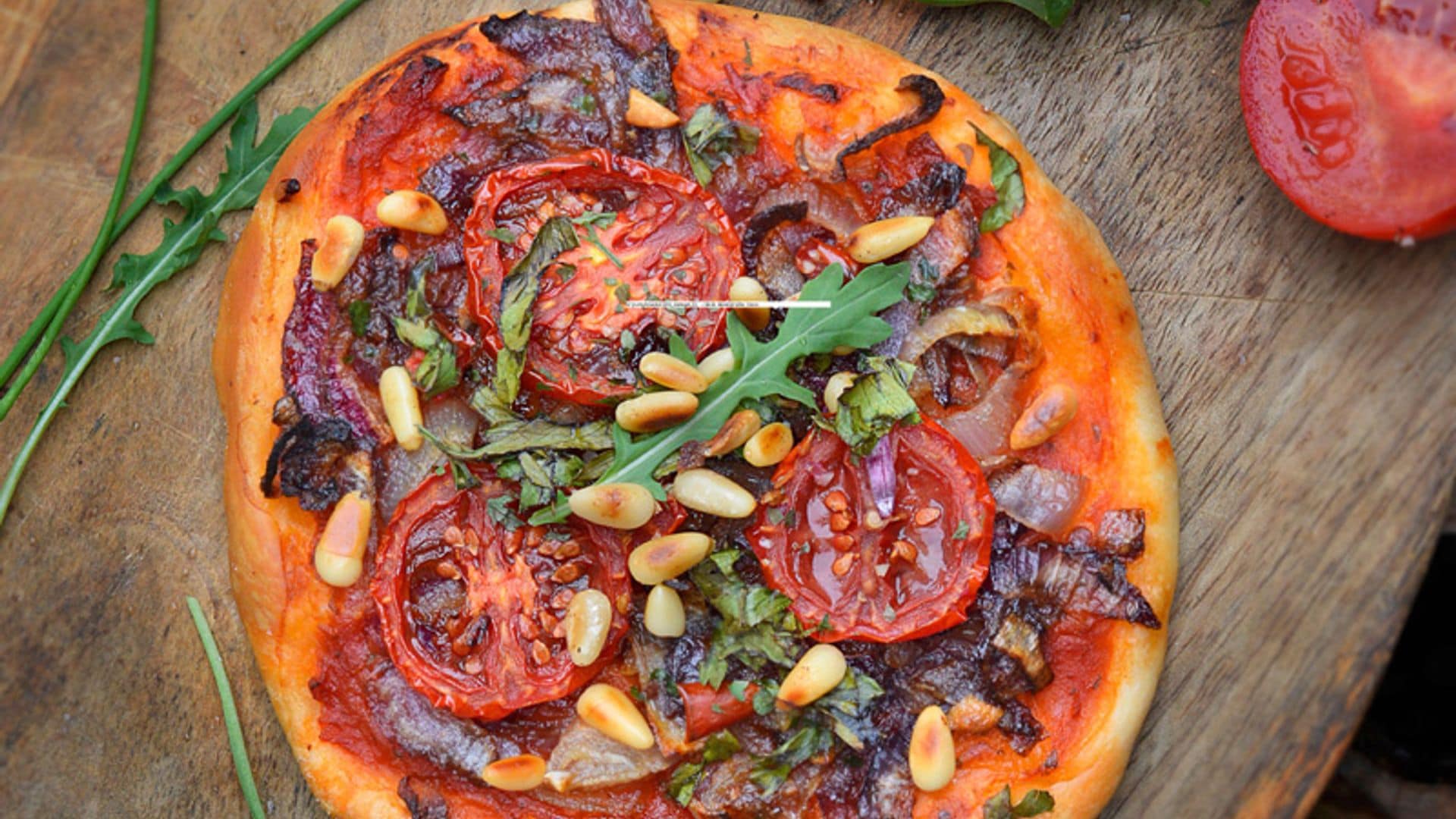 Pizza de tomate, cebolla y piñones