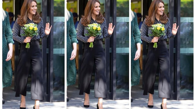 kate middleton en un look de pantalones culotte negros y blusa con estampado de lunares