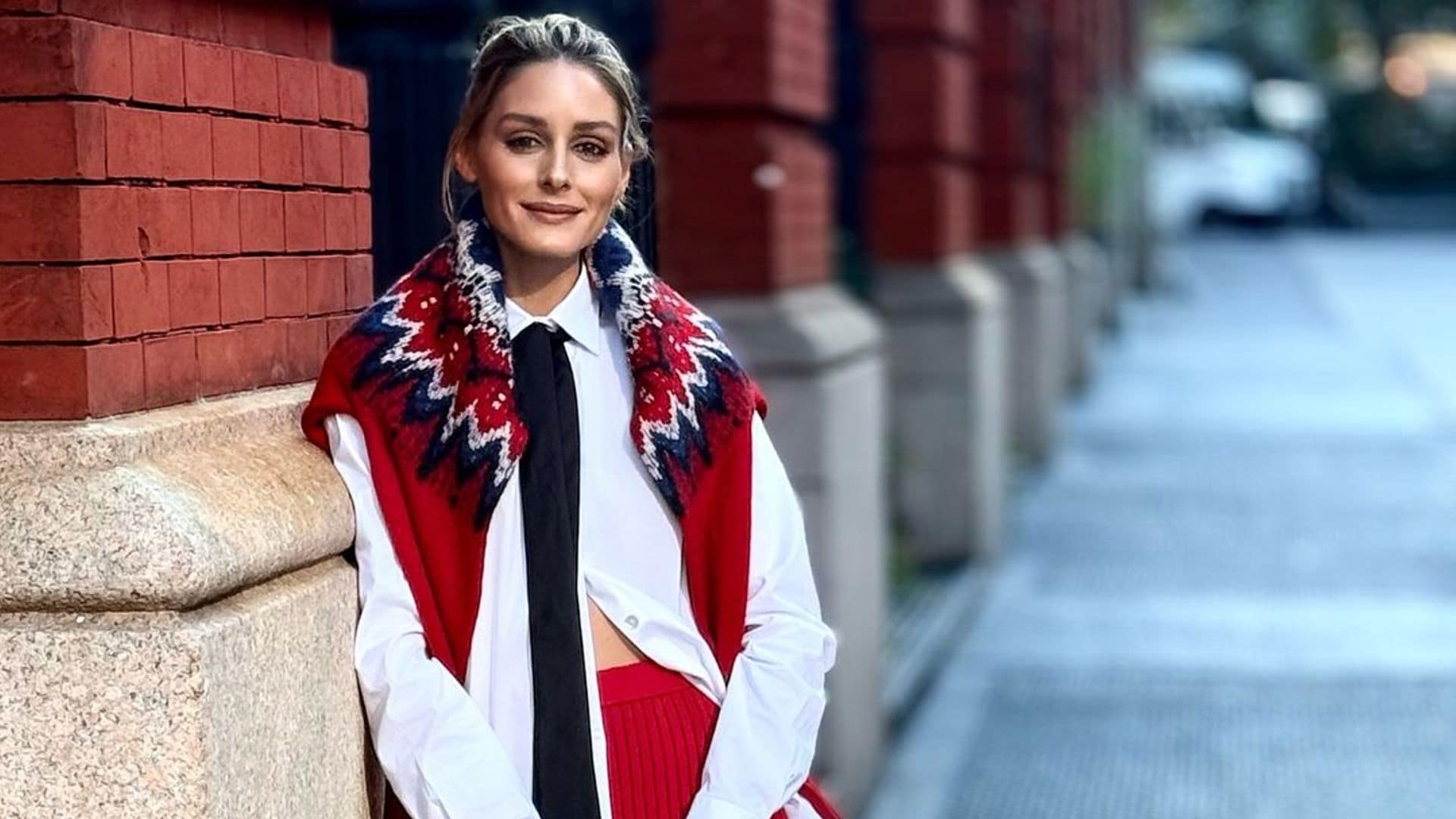 El look multitendencia de Olivia Palermo en Nueva York: corbata, jersey sobre los hombros y falda ‘midi’ de punto