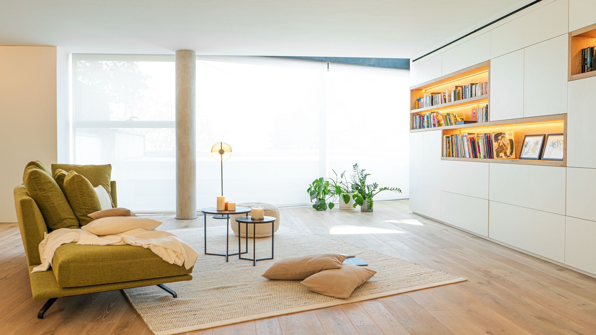 Salón con mueble a medida de pared a pared con zonas abierta y cerradas, alfombra, sofá y cojines de suelo