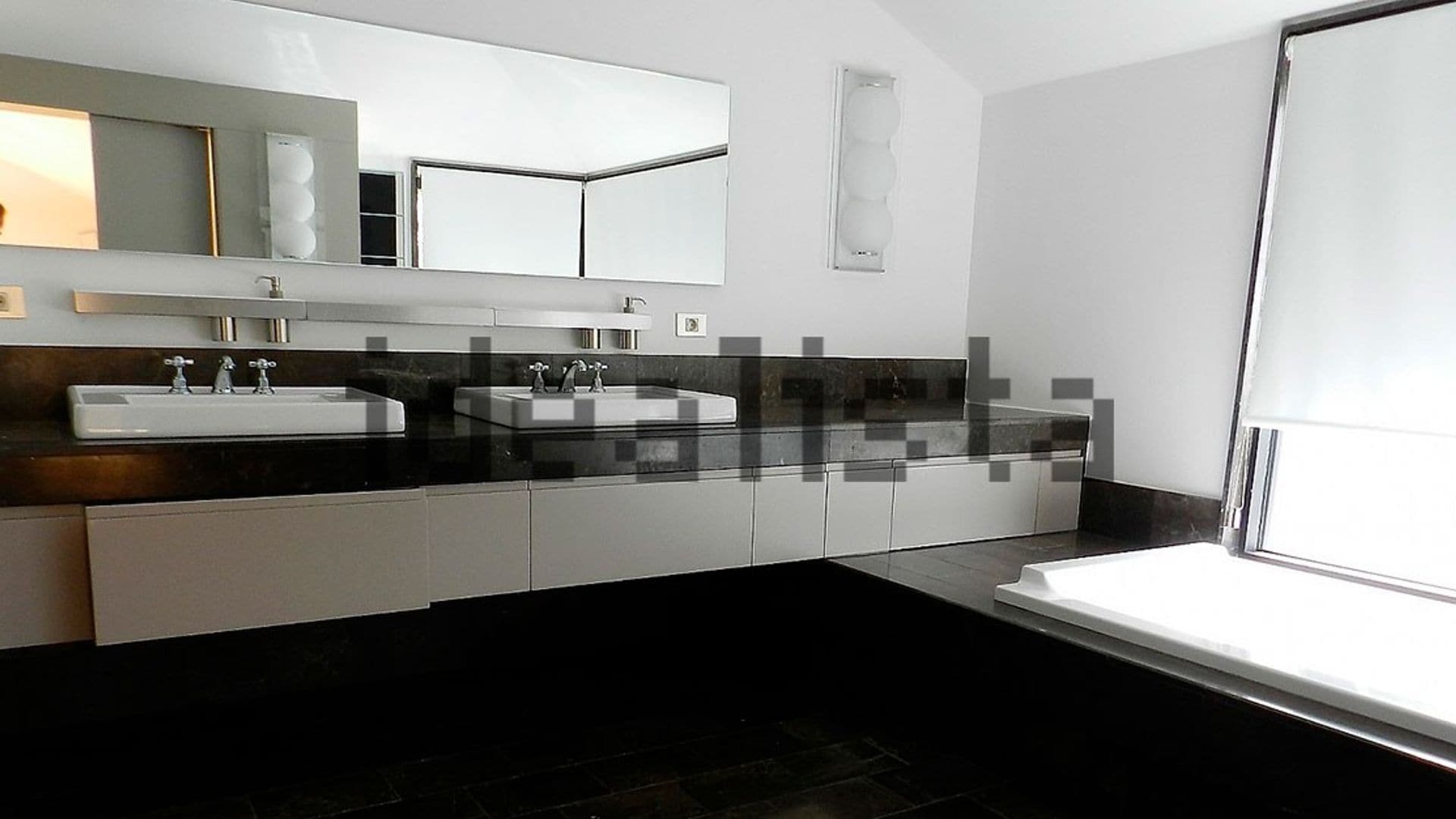 Baño en blanco y negro con lavamanos doble, bañera y espejo rectangular sin arco