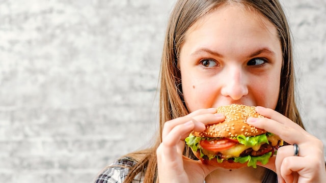 joven comiendo hamburguesa