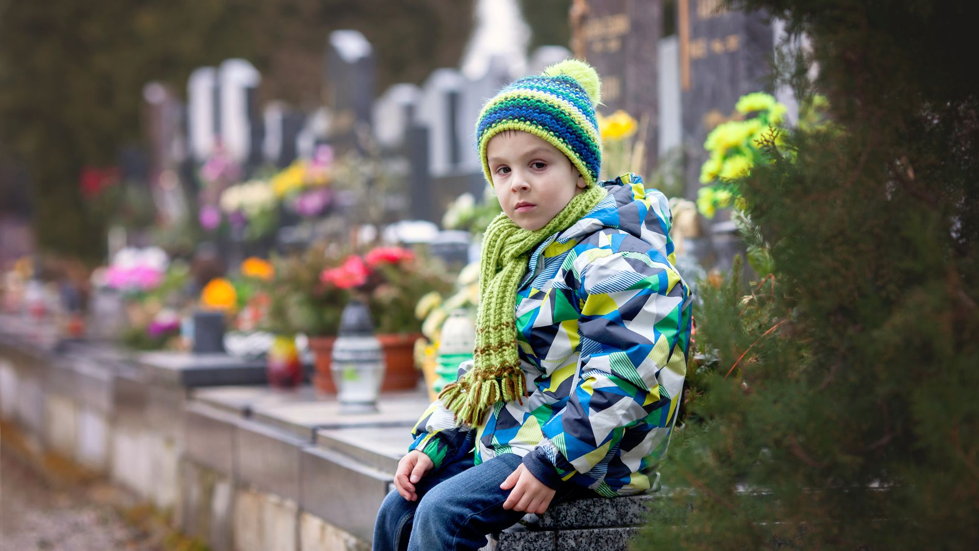 Niño triste, en un cementerio