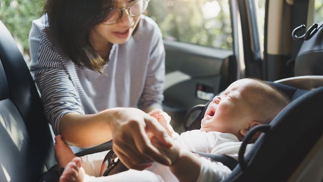 beb llorando mientras mam lo sienta en la sillita del coche