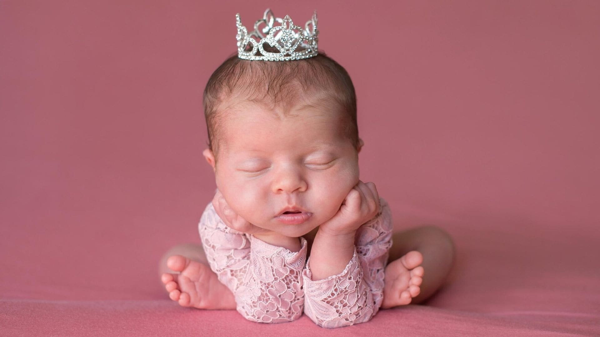 sleeping newborn baby girl wearing a tiara