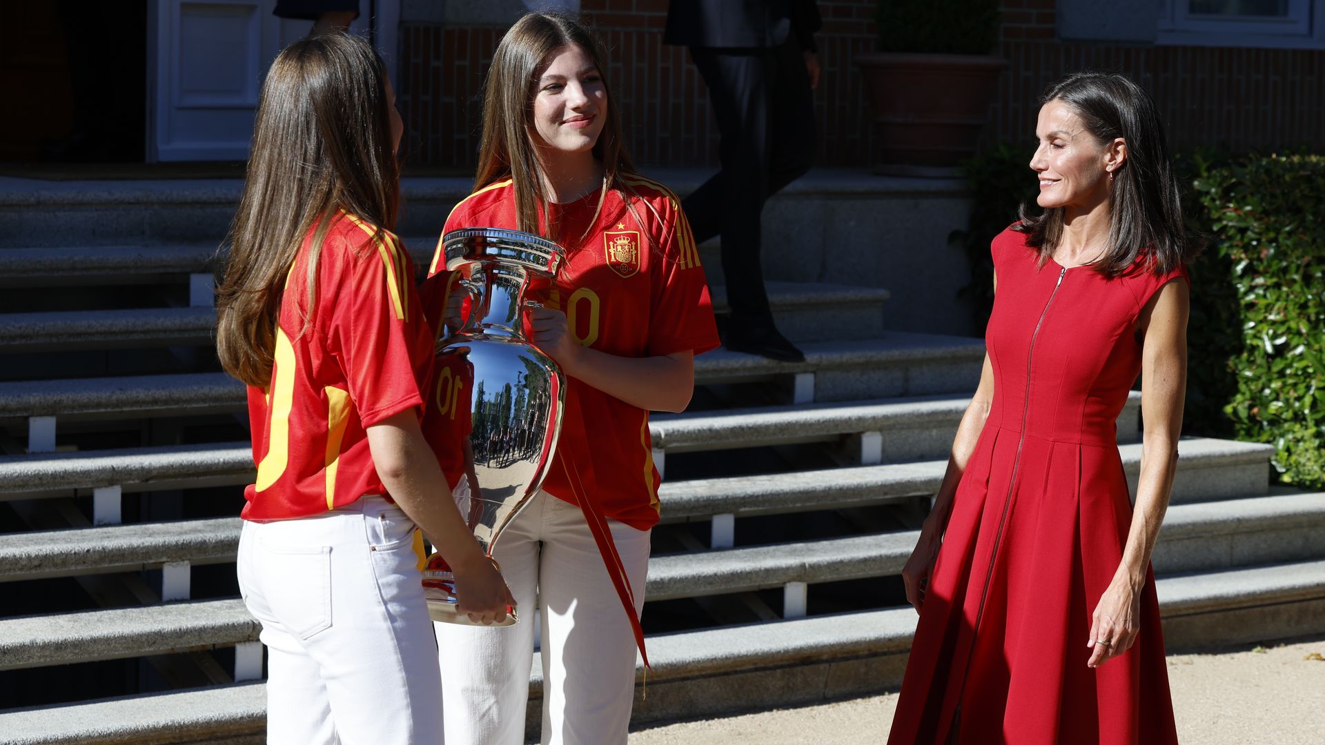 La reina Letizia viste de rojo y sus hijas con camisetas deportivas para felicitar a los futbolistas de España