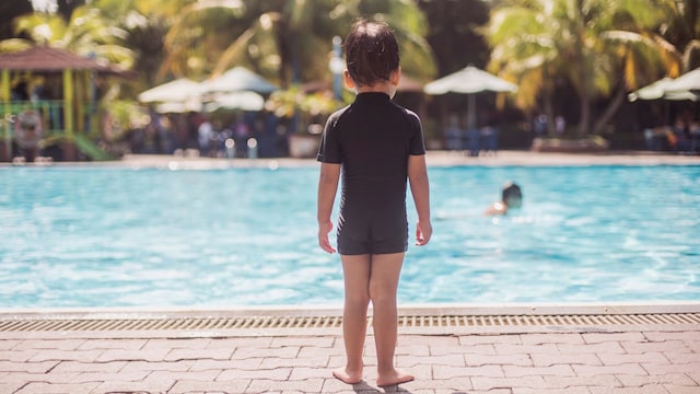 Niño frente a una piscina