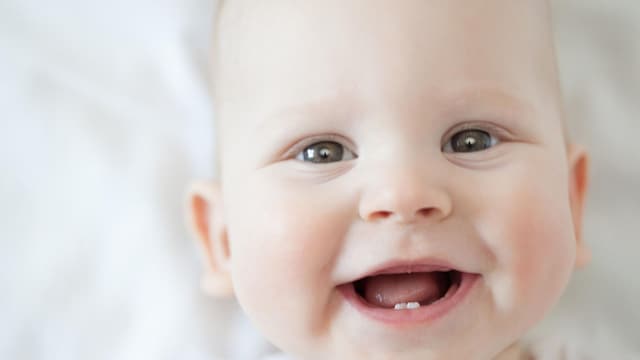 beb sonriendo con sus primeros dientes