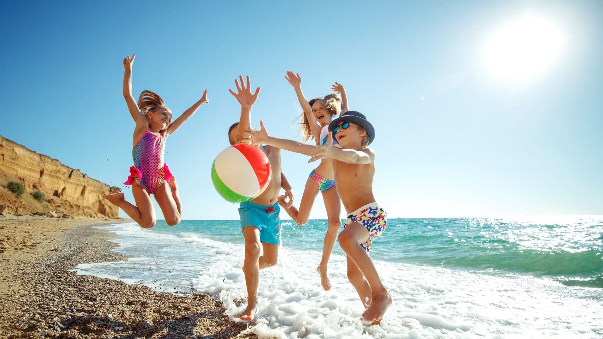 Niños divirtiéndose en la playa de arena en verano.