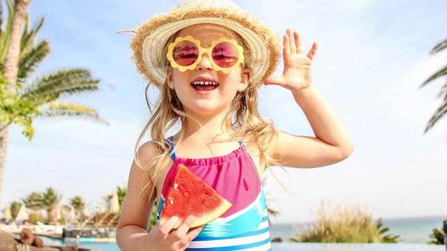 ni a comiendo sand a en verano en la piscina 