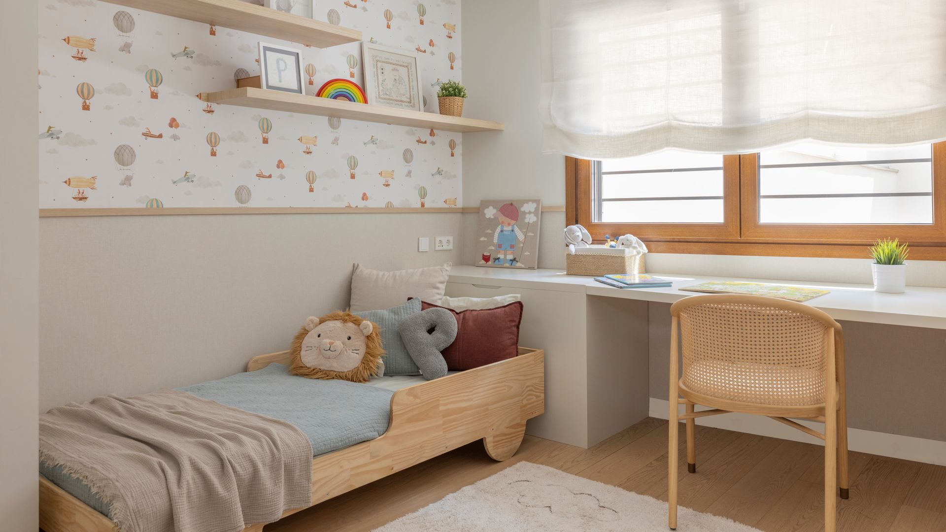 Habitación infantil con escritorio bajo la ventana, cama de madera, zócalo y papel pintado