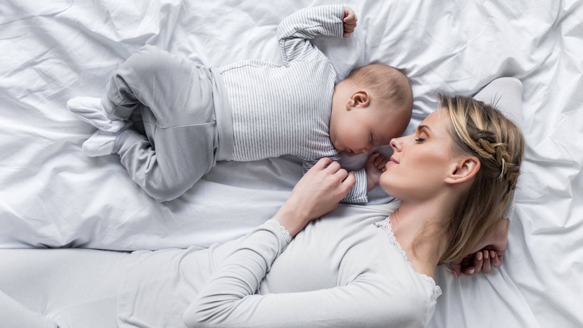 Madre duerme junto a su bebé