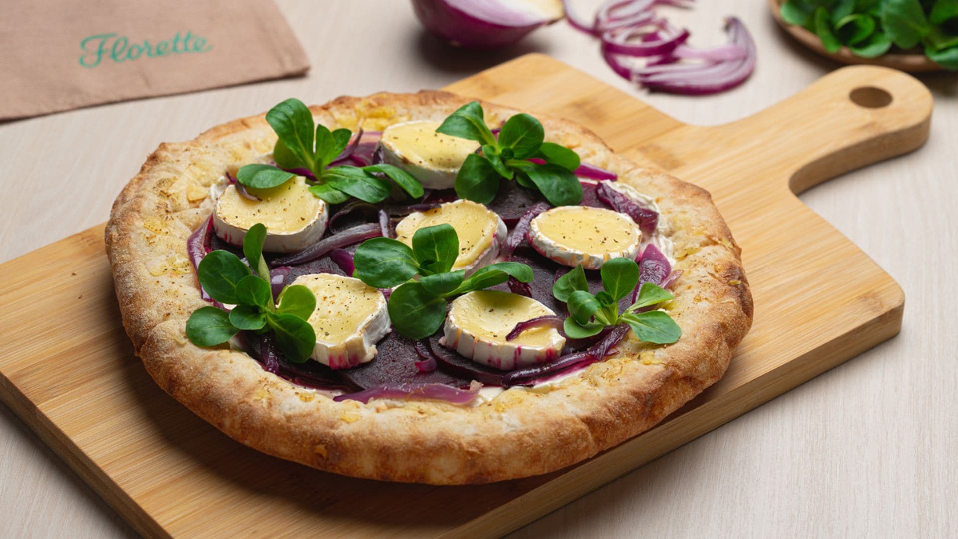 Pizza de remolacha y cebolla morada caramelizada con queso de cabra y canónigos