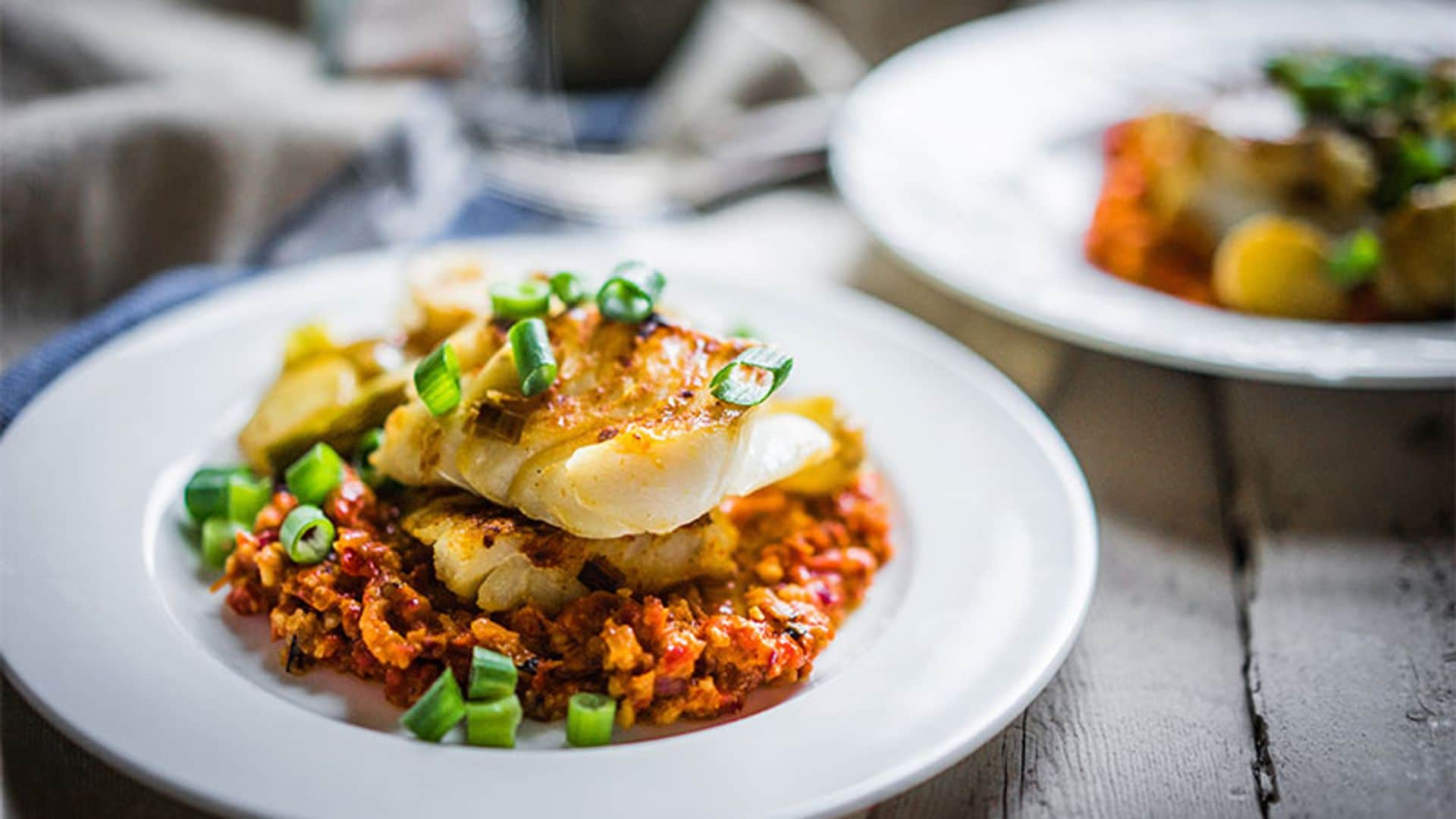 Merluza con salsa romesco y cebolla de verdeo