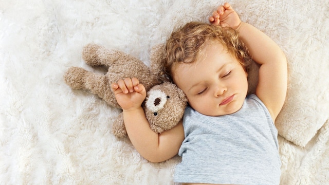 Niña durmiendo en la cama plácidamente con su osito de peluche