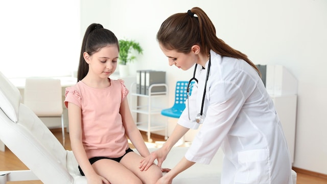 pediatra revisando piernas a una ni a