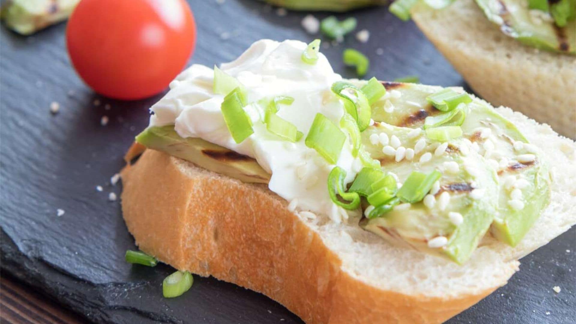 Tostas de aguacate a la parrilla con queso crema, cebolleta y sésamo