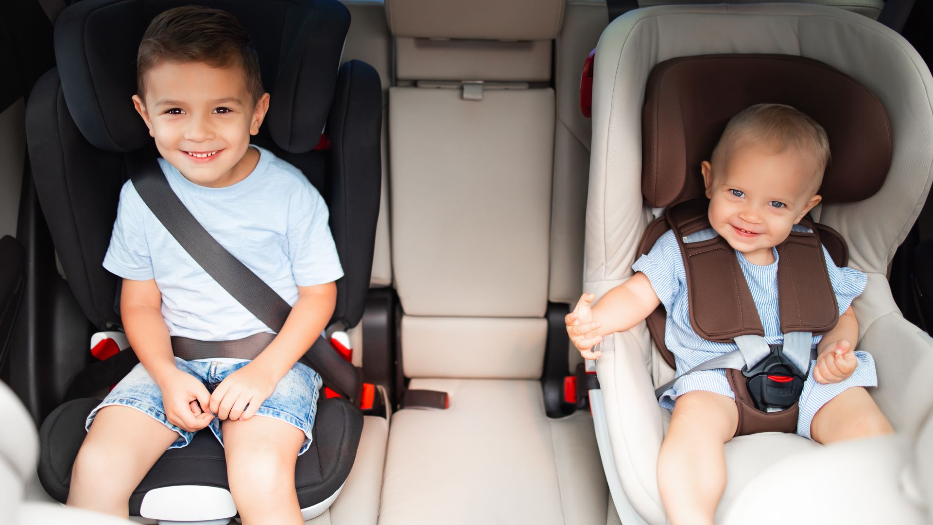 Dos niños sentados en sus sillitas para coche