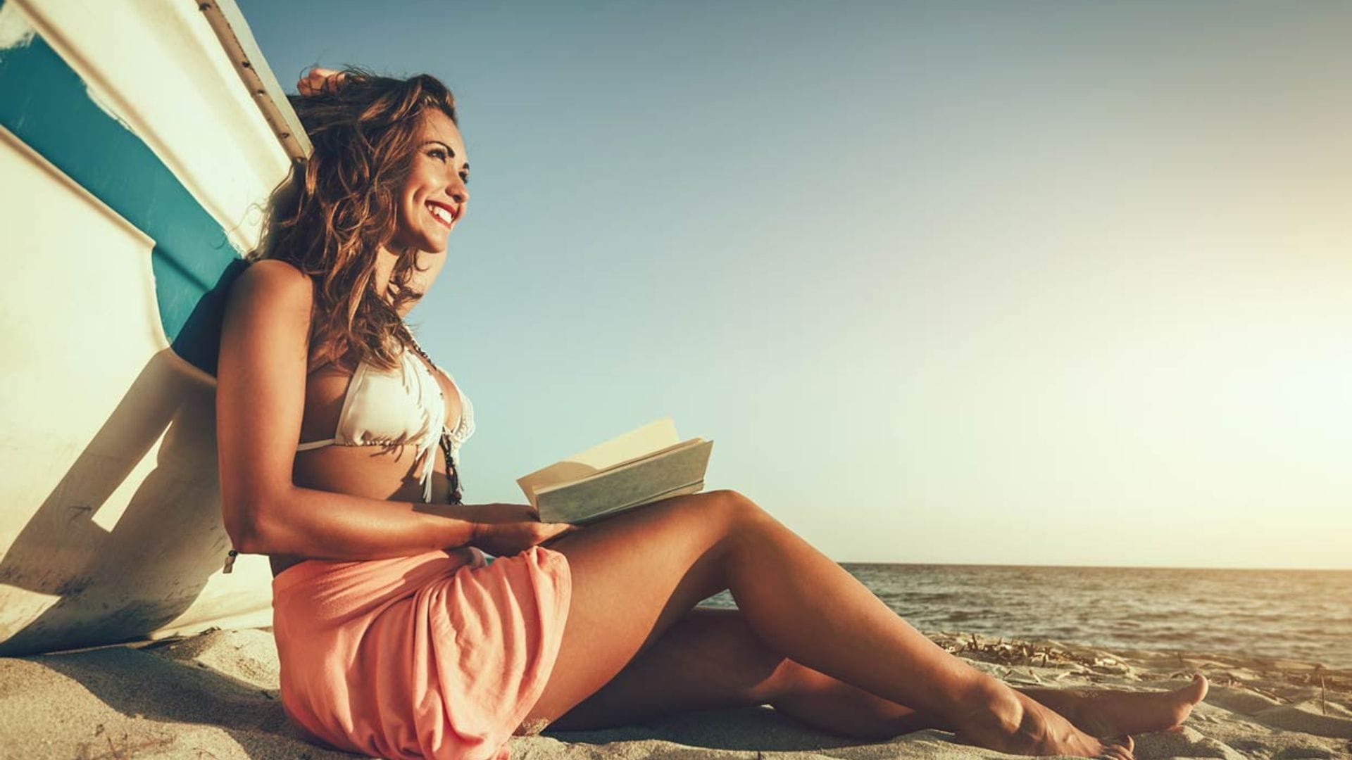 Mujer leyendo un libro en la playa