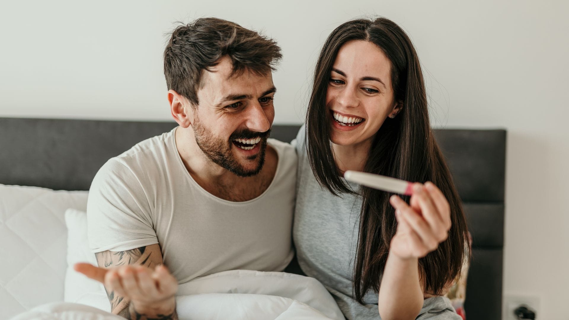 Pareja mira, feliz, el resultado positivo de un test de embarazo