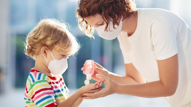 madre e hijo con mascarilla y gel en la calle 